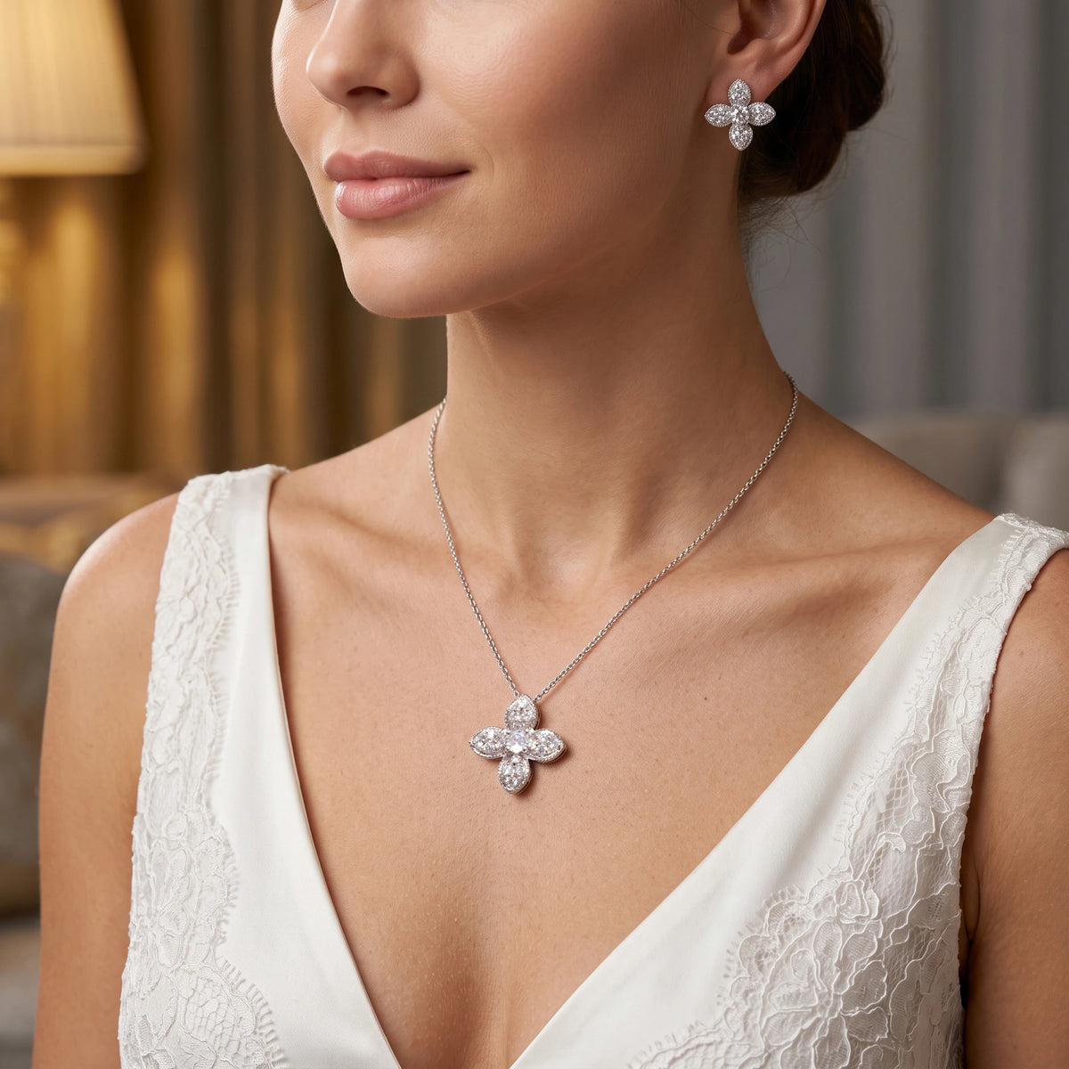 طقم مجوهرات الزهر الرباعي الناعم مع ترصيع مكثف بأحجار الزركون البيضاء الشفافة Delicate four-petal floral jewelry set, richly studded with clear white zircon stones.